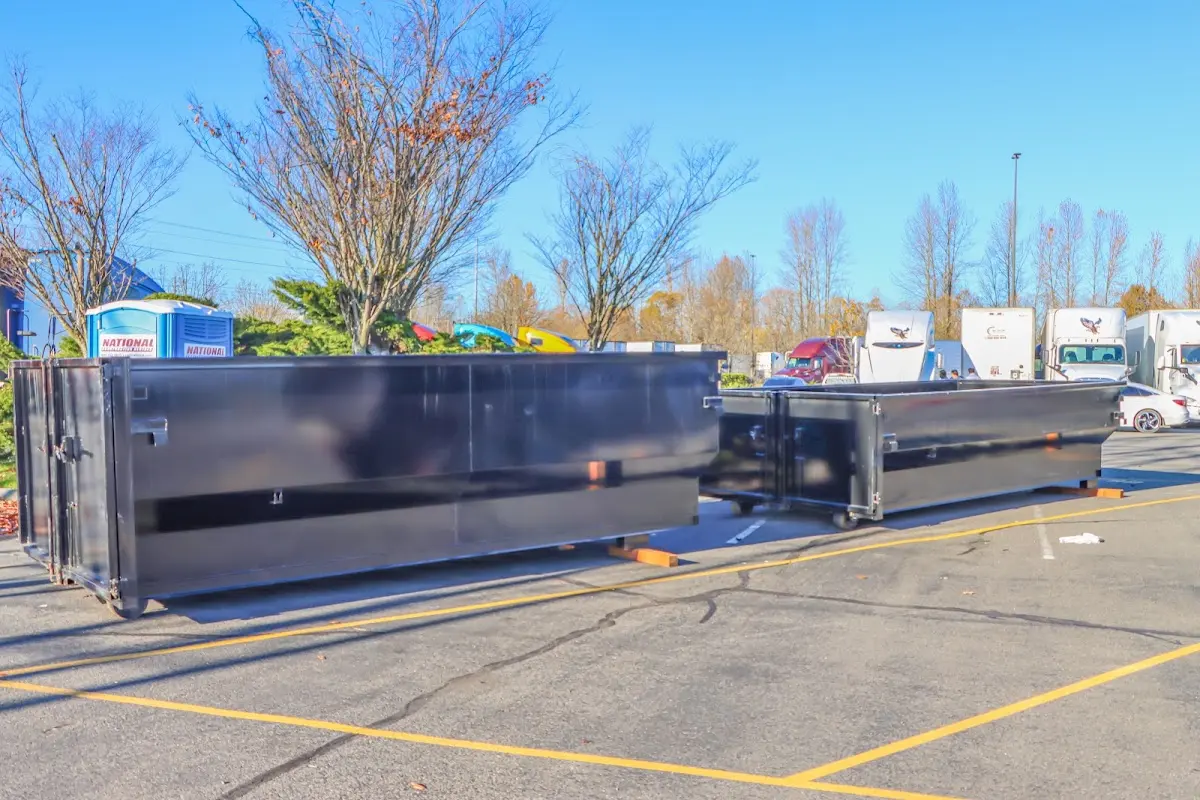 Professional dumpster rental service with roll-off container on residential driveway in Missoula